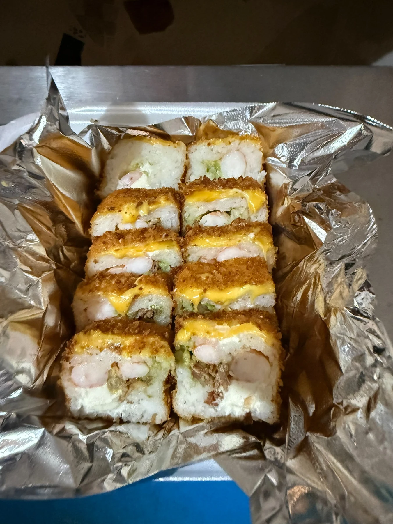 Rollo empanizado servido en charola de aluminio